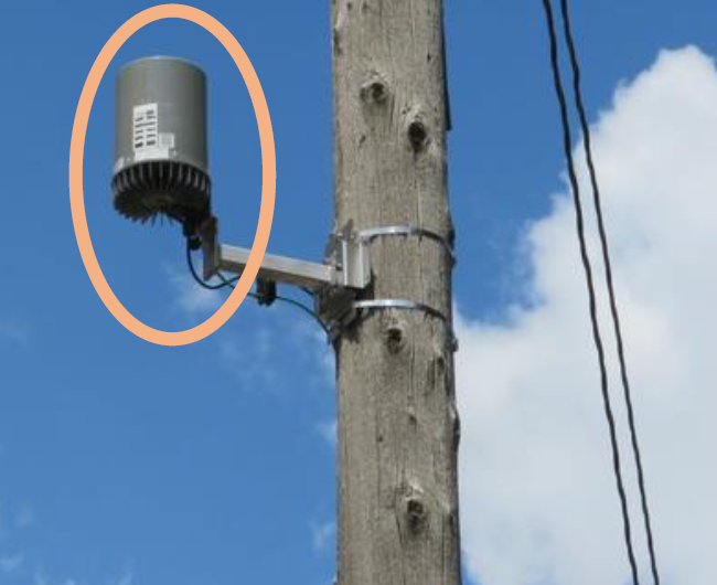 Photo of a utility pole with a small cell wireless facility mounted near the top of the pole