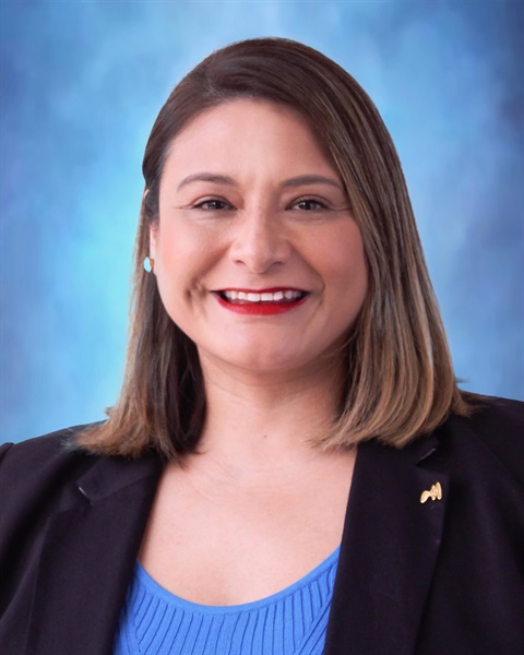 portrait photograph of a smiling woman with brown shoulder length hair 